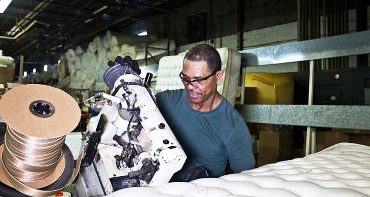 Un trabajador utiliza una máquina de coser en una fábrica de colchones Saatva. / Foto: The New York Times. 